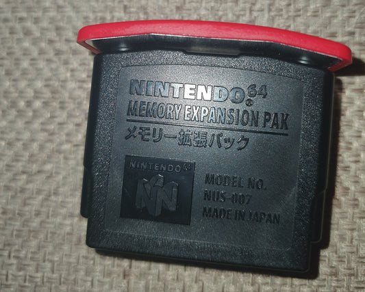 Nintendo 64 N64 Expansion Pack on a textured surface