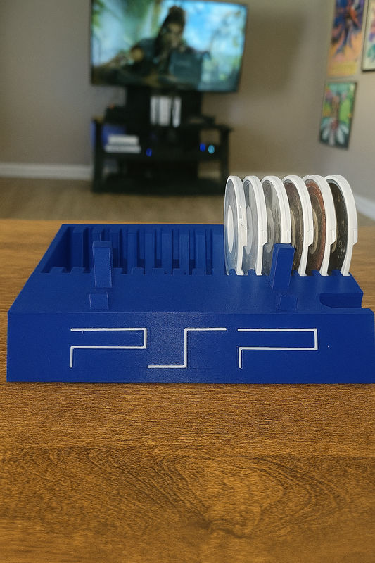 Blue PSP console stand with memory cards on a wooden surface, TV in the background