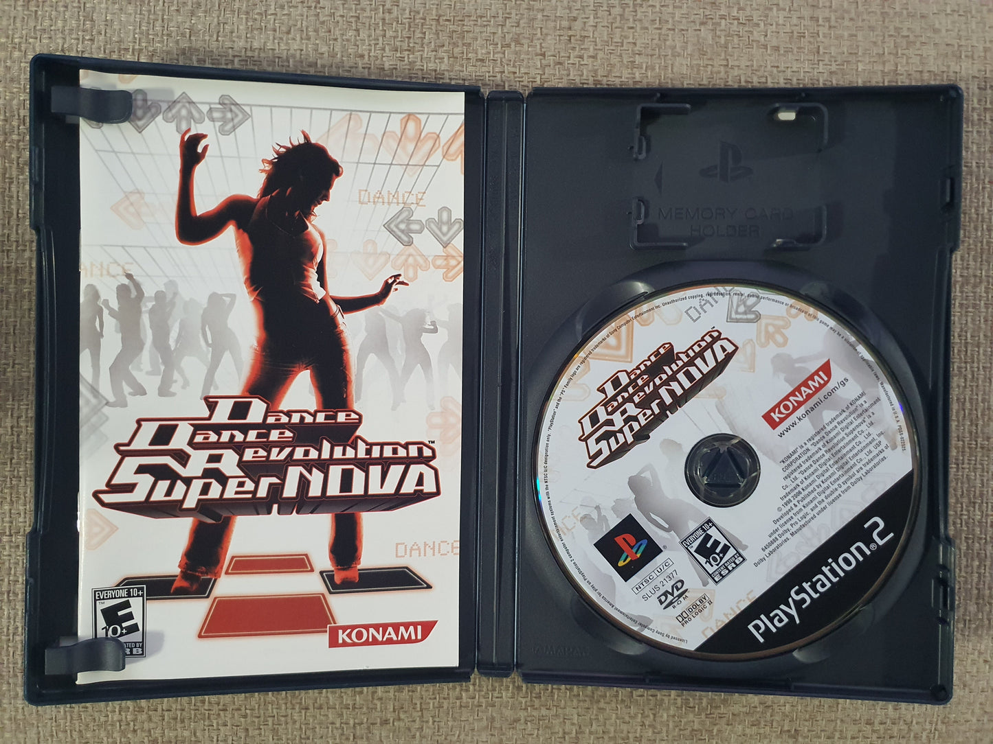 Dance Dance Revolution SuperNova game case and disc on a textured surface