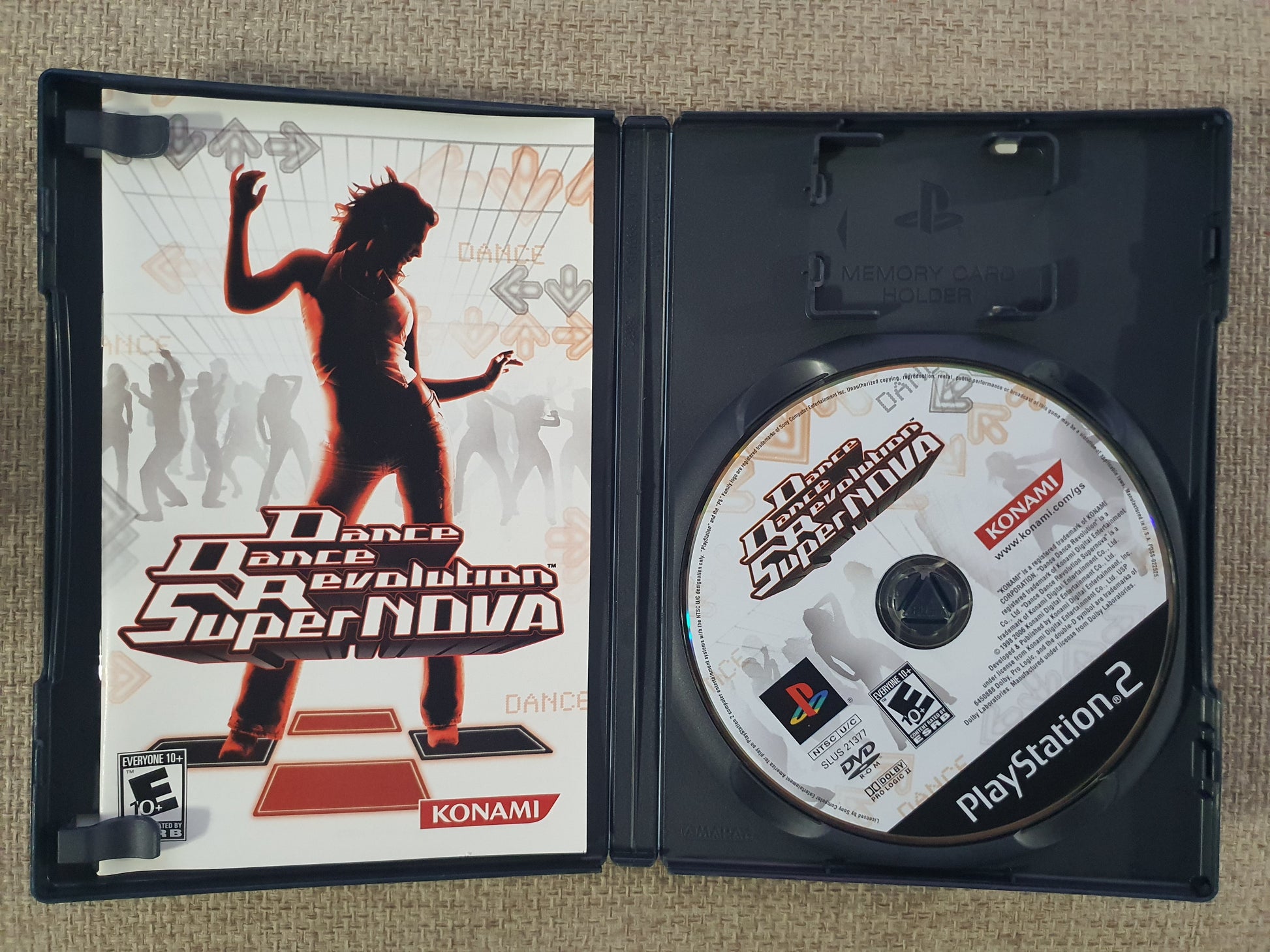 Dance Dance Revolution SuperNova game case and disc on a textured surface