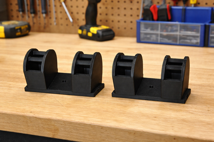 Two black plastic stands on a wooden surface with tools in the background