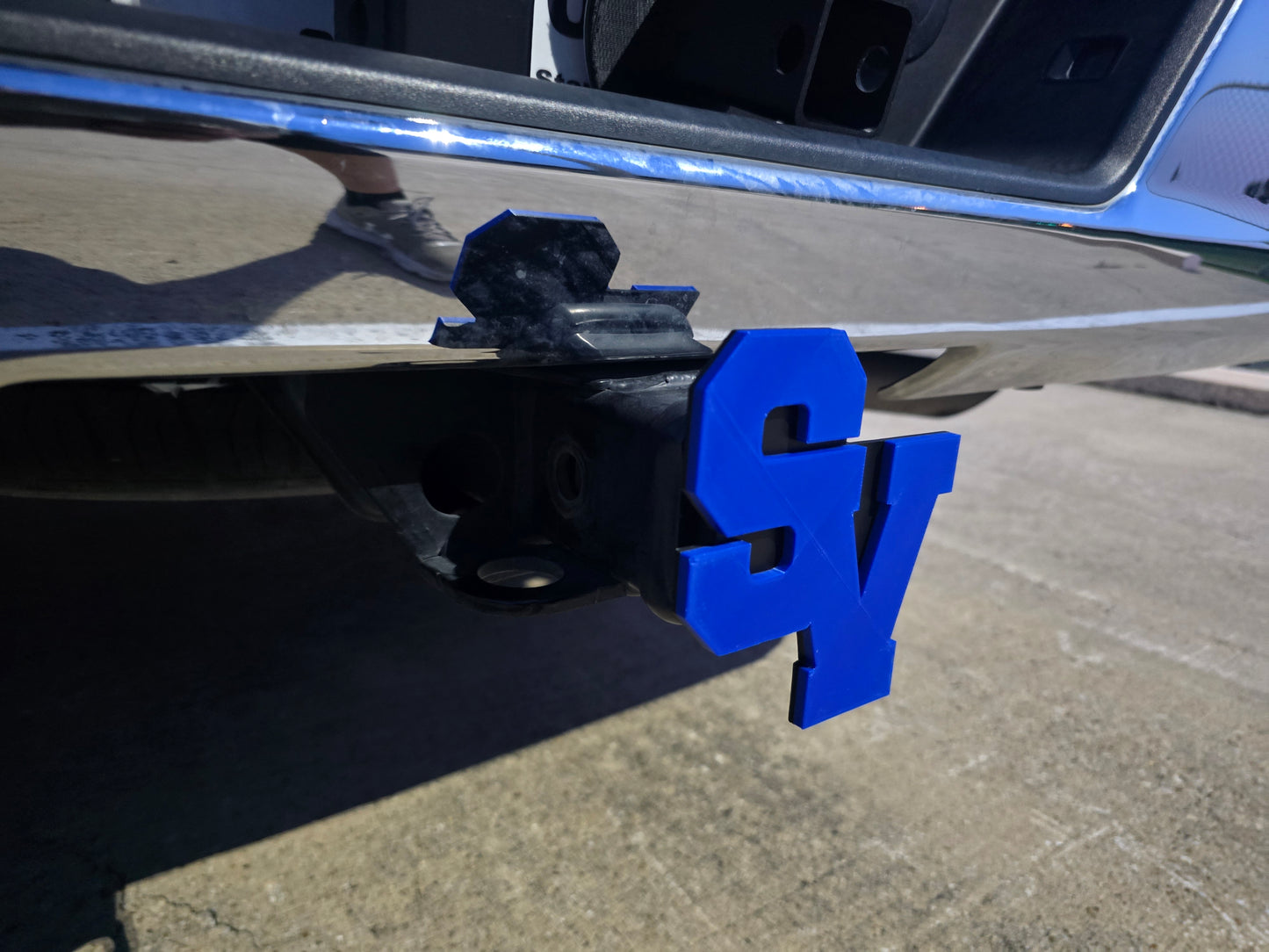 Blue hitch receiver on a vehicle with a visible 'SY' logo.