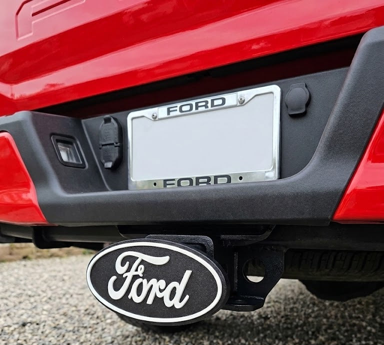 Ford vehicle's hitch receiver with a red car in the background