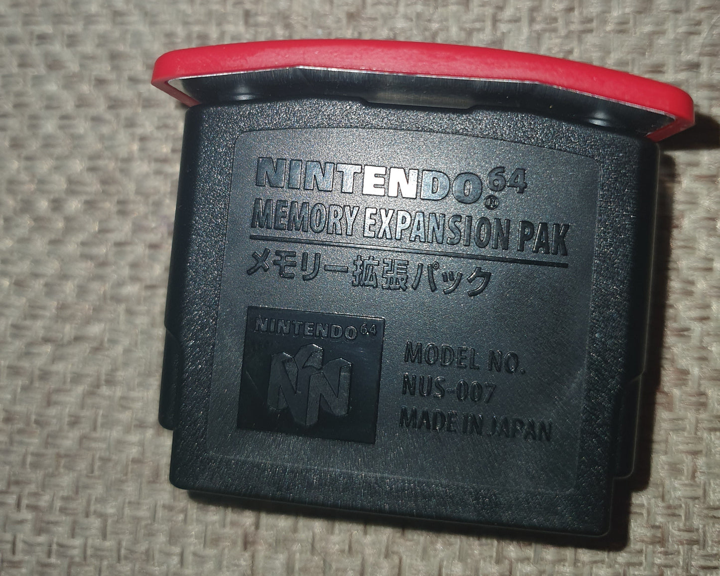 Nintendo 64 N64 Expansion Pack on a textured surface