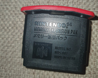 Nintendo 64 N64 Expansion Pack on a textured surface