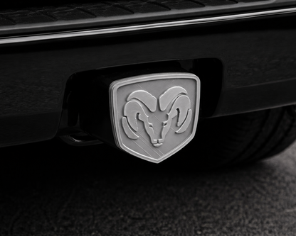 Close-up of a Ram logo on a vehicle's hitch receiver.