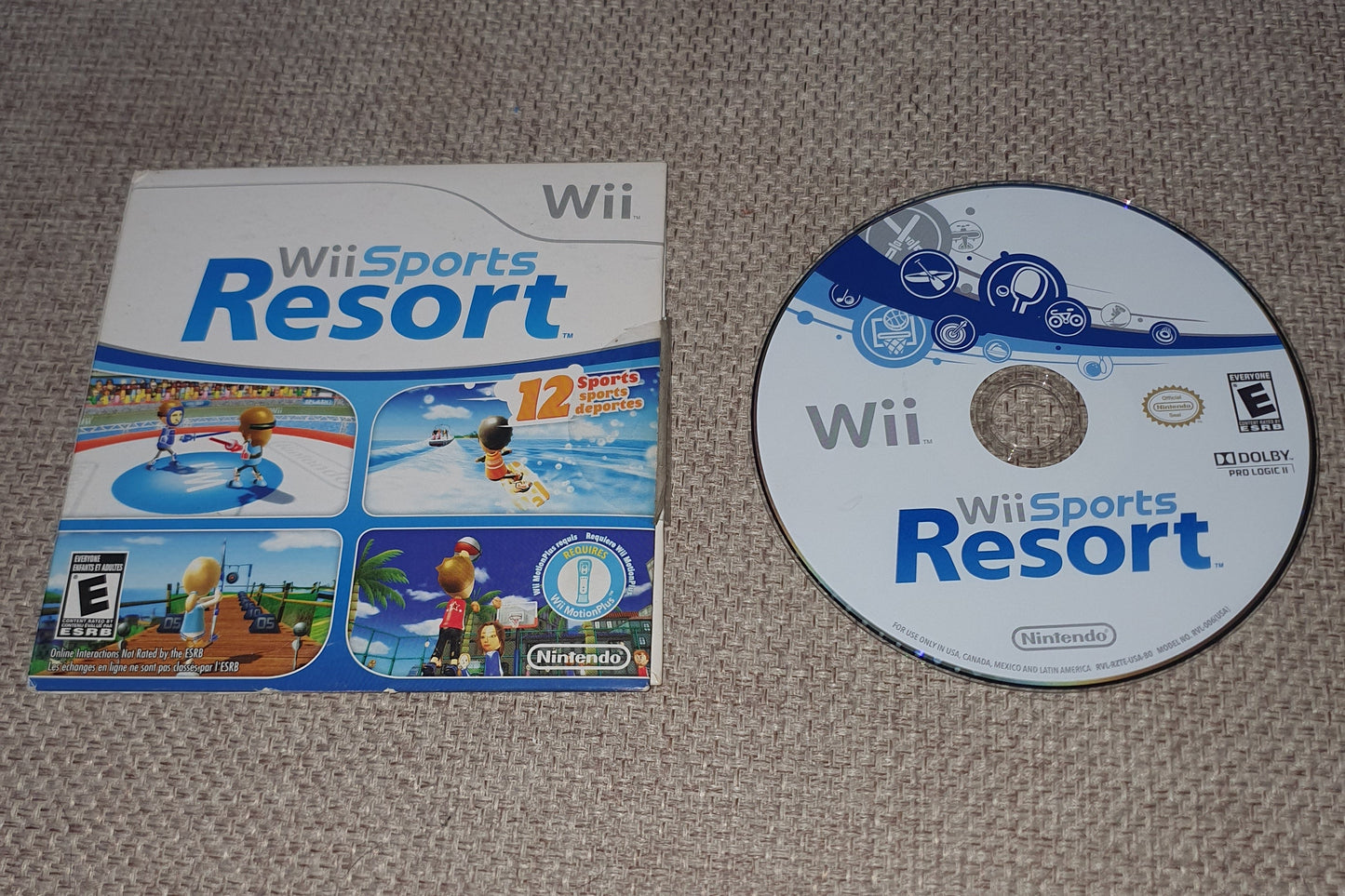 Wii Sports Resort game disc and cover on a textured surface